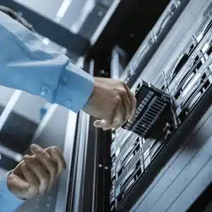 Technician replacing hard drive in data center server rack to resolve server failure