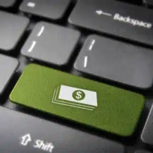 Close-up of keyboard with a green dollar icon key, symbolizing online transactions or payments