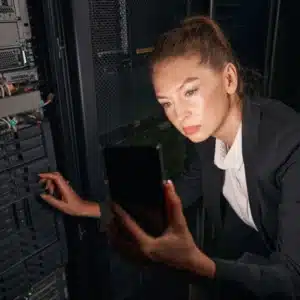 Professional checks server with tablet during routine cyber managed services monitoring and updates