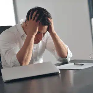 A man stressed over computer issues, showing the need for proactive IT support solutions