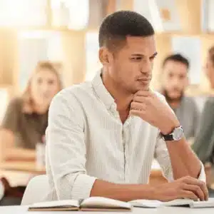 Professional studies notes at laptop during training session, focusing on project requirements and implementation details