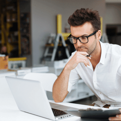 IT consultant reviews system plans on laptop at desk; Lenovo vs Dell servers options carefully
