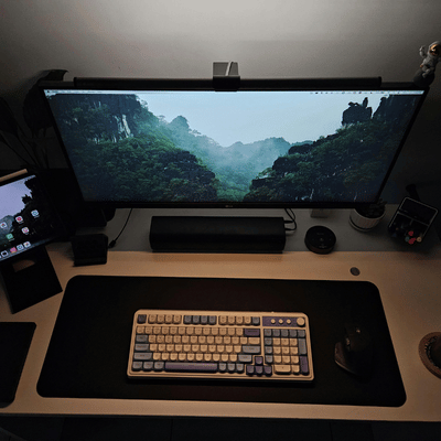 An ultrawide monitor workstation displays a landscape scene, showing servers and workstations used for focused technical tasks
