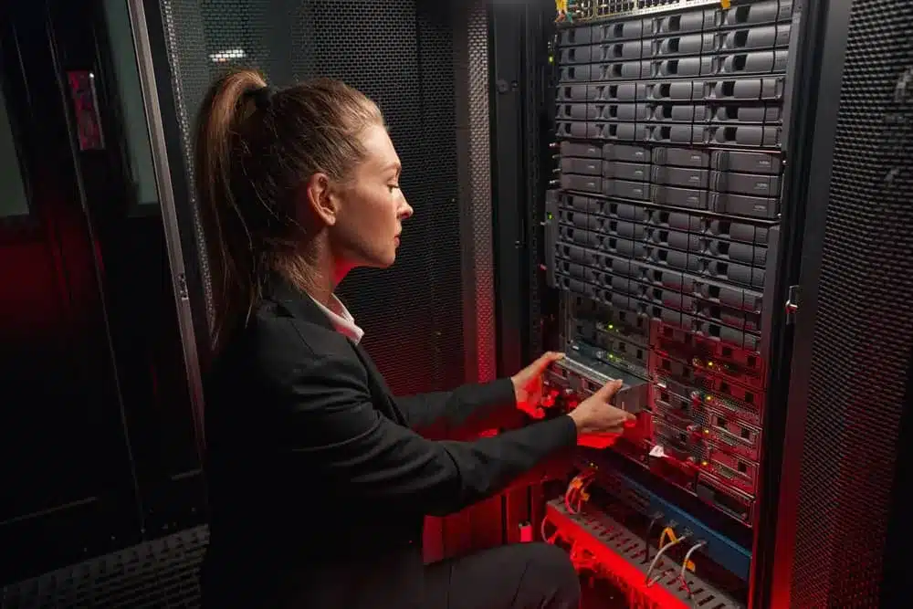 Female engineer working on hardware in a dark server room
